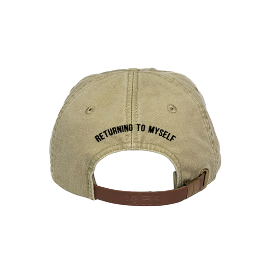 Back of a beige cap with 'RETURNING TO MYSELF'